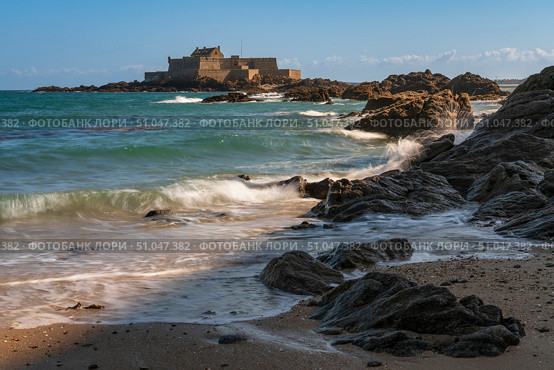 View of the Petit Be Fort on a small island and the exposed ocean floor at low tide on a sunny summer day, Saint-Malo, Brittany, France. Стоковое фото, фотограф Ula Ulachka / Фотобанк Лори