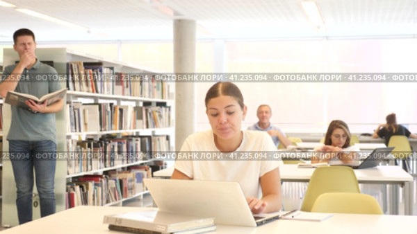 View on bored young caucasian latina student with a laptop in the school library. Стоковое видео, видеограф Яков Филимонов / Фотобанк Лори