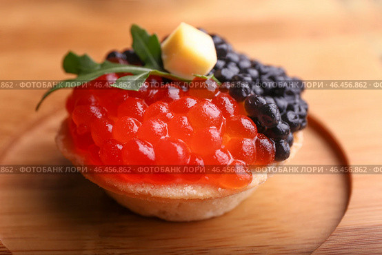 Вкусная корзиночка с икрой на деревянной доске, крупным планом. Стоковое фото, фотограф Pixel_shot / Фотобанк Лори