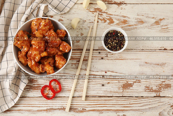 Вкусное сладко-кислое куриное мясо в миске с пряностями на светлом деревянном фоне. Стоковое фото, фотограф Pixel_shot / Фотобанк Лори