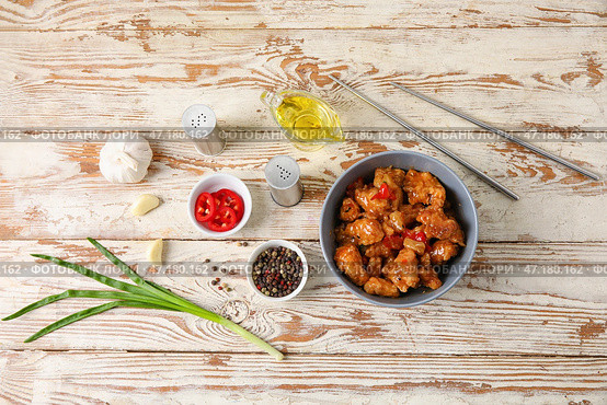 Вкусное сладко-кислое куриное мясо в миске с пряностями на светлом деревянном фоне. Стоковое фото, фотограф Pixel_shot / Фотобанк Лори