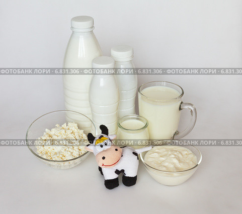 Вкусные молочные продукты и веселая игрушечная корова на белом. Стоковое фото, фотограф Виктория Катьянова / Фотобанк Лори