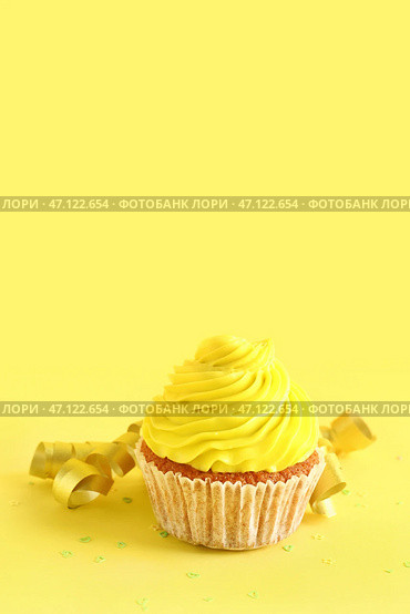 Вкусный кекс и конфетти на желтом фоне. Стоковое фото, фотограф Pixel_shot / Фотобанк Лори