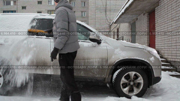 Водитель очищает автомобиль от снега во время прогрева двигателя, зима, таймлапс. Стоковое видео, видеограф Кекяляйнен Андрей / Фотобанк Лори