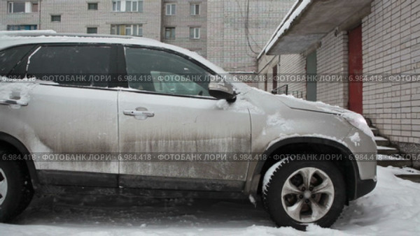 Водитель сметает снег с автомобиля на стоянке. Стоковое видео, видеограф Кекяляйнен Андрей / Фотобанк Лори