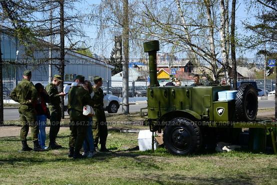 Военно-полевая кухня стоит на улице рядом с парнями в военной форме и девушками (2015 год). Редакционное фото, фотограф Светлана Грызлова / Фотобанк Лори