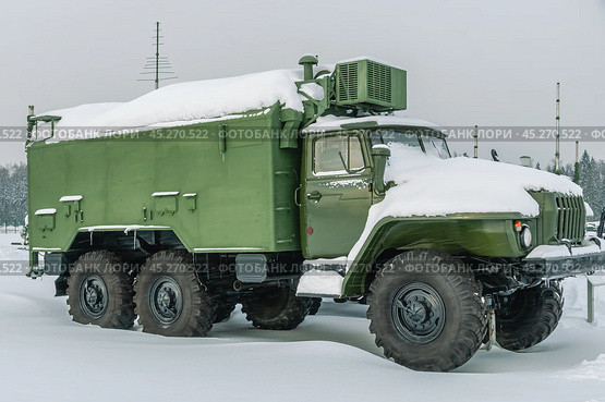 Военный грузовик с кузовом для перевозки людей и грузов. Военный грузовик зимой стоит в сугробах. Трехосный армейский грузовик повышенной проходимости в снегу во время снегопада. Стоковое фото, фотограф Эдуард Белкин / Фотобанк Лори