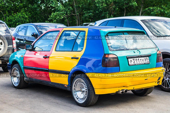 Volkswagen Golf Harlekin old car on the city parking. Parts of the car are painted in different colors (2021 год). Редакционное фото, фотограф Константин Григорьев / Фотобанк Лори
