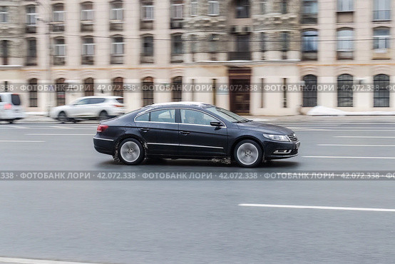 Volkswagen Passat CC Facelift car moves on multi-lane road. Old buildings on the opposite side of the road. Редакционное фото, фотограф Константин Григорьев / Фотобанк Лори
