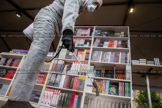 Волонтер во время проведения дезинфекции на ежегодном книжном фестивале "Красная площадь" в центре города Москвы во время эпидемии коронавируса COVID-19 в России (2020 год). Редакционное фото, фотограф Николай Винокуров / Фотобанк Лори