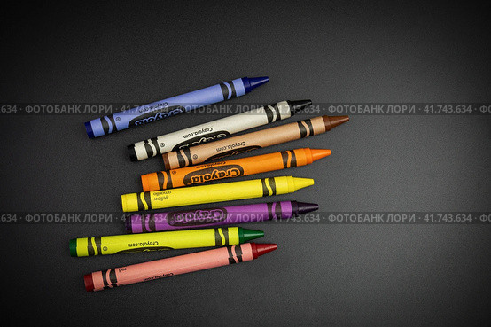 Восемь цветных восковых мелков Crayola россыпью на чёрной поверхности - Россия, Санкт-Петербург, Ноябрь 2023. Редакционное фото, фотограф Мария L. / Фотобанк Лори