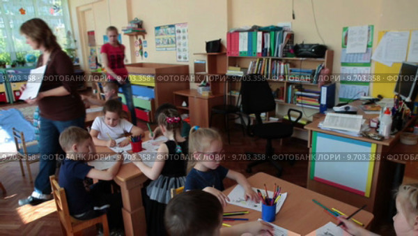 Воспитатель рассказывает и показывает задание детям во время урока в детском садике (2015 год). Редакционное видео, видеограф Кекяляйнен Андрей / Фотобанк Лори