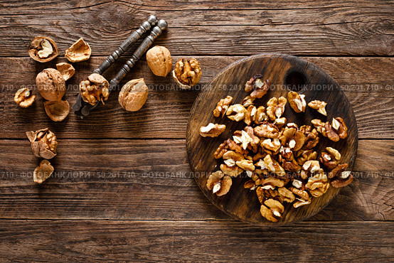 Walnuts. Kernels and whole nuts on wooden rustic table, top view. Стоковое фото, агентство Ingram Publishing / Фотобанк Лори