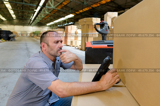 warehouse worker or supervisor with barcode scanner. Стоковое фото, агентство Ingram Publishing / Фотобанк Лори