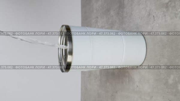Water is poured into a white thermos mug. Стоковое видео, видеограф Катерина Белякина / Фотобанк Лори