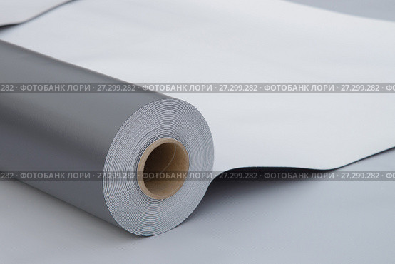 Waterproofing and insulation at construction site, opened pvc membrane roll lying on roof closeup. Copy space for your text. Стоковое фото, фотограф Сергей Дорошенко / Фотобанк Лори