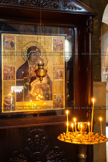 Wax candles burn in front of  icon of the Mother of God. Стоковое фото, фотограф Юлия Бабкина / Фотобанк Лори