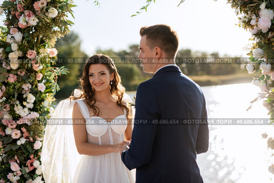 wedding ceremony on a high pier near the river with invited guests. Стоковое фото, агентство Ingram Publishing / Фотобанк Лори
