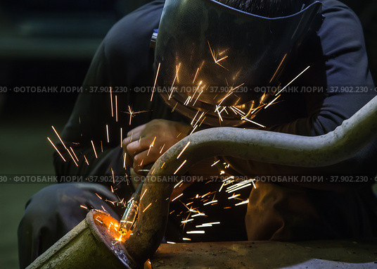 Welder repairing a car exhaust pipe. Стоковое фото, фотограф Юрий Бизгаймер / Фотобанк Лори