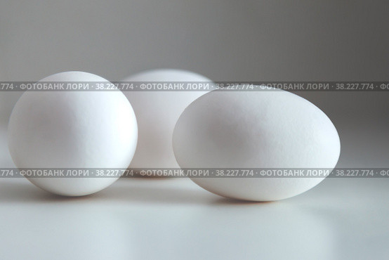 White chicken eggs on white background. Egg on table, natural healthy food. Creative minimalistic background. Concept organic farming and proper nutrition. Place for an inscription or logo. Стоковое фото, фотограф Aleksandr Golubev / Фотобанк Лори