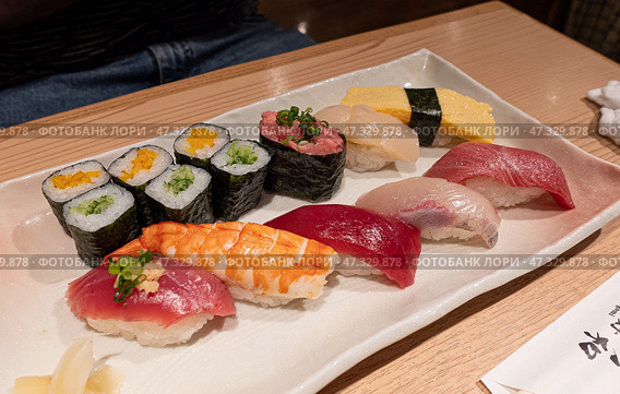 White plate beautifully topped with sushi on a table in Japan subway restaurant. Стоковое фото, фотограф Ignacio Martinez / Фотобанк Лори