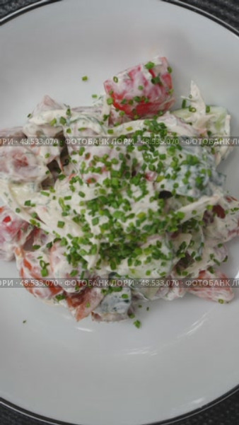 White sauce cascading over fresh garden salad, featuring ripe tomatoes, crisp cucumbers, and sliced onions, garn. Стоковое видео, видеограф Данил Руденко / Фотобанк Лори