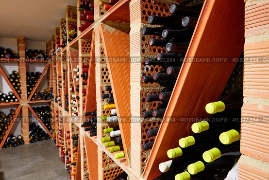 Wine Cellar from Mediterranean with bottles stacked in rows. Стоковое фото, агентство Ingram Publishing / Фотобанк Лори