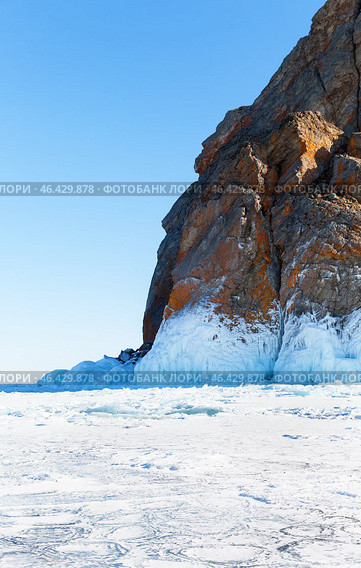 Winter landscape of frozen Baikal Lake. View of natural landmark of Olkhon Island, famous Cape Khoboy, called Deva Rock on sunny February day. Tourist attraction for active recreation. Стоковое фото, фотограф Виктория Катьянова / Фотобанк Лори