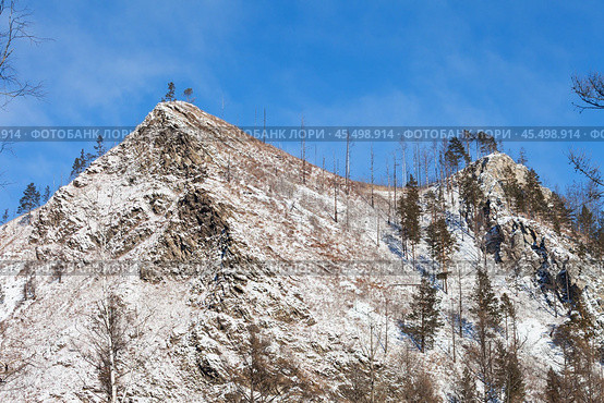 Winter landscape with snow-capped peaks of rocky mountains near Goloustnaya River on sunny January day. Baikal region, Pribaikalsky national park. Beautiful nature background. Winter travels. Стоковое фото, фотограф Виктория Катьянова / Фотобанк Лори