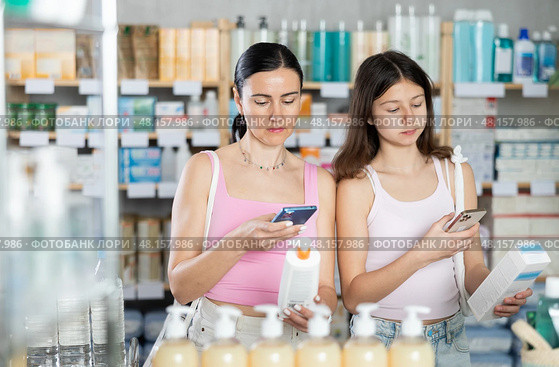 Woman and girl daughter in pharmacy scans QR code on cream. Стоковое фото, фотограф Яков Филимонов / Фотобанк Лори