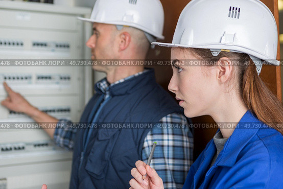 woman and teacher measuring electrical current of a fuse board. Стоковое фото, агентство Ingram Publishing / Фотобанк Лори