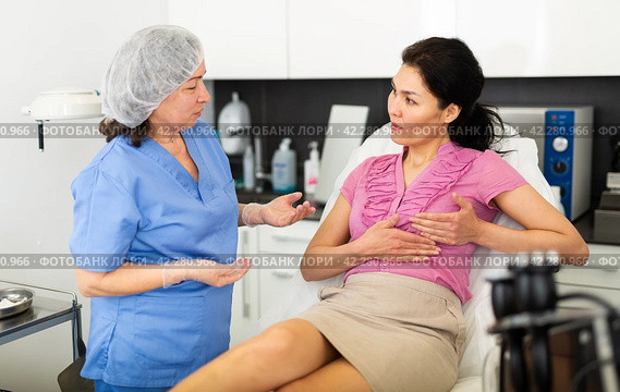 Woman asking cosmetologist about breast lift and reshaping procedures. Стоковое фото, фотограф Яков Филимонов / Фотобанк Лори