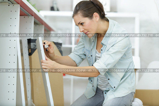 woman assembling kitchen base units. Стоковое фото, агентство Ingram Publishing / Фотобанк Лори