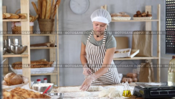 Woman baker cutting dough pieces with scraper and weighing in scales. Стоковое видео, видеограф Яков Филимонов / Фотобанк Лори