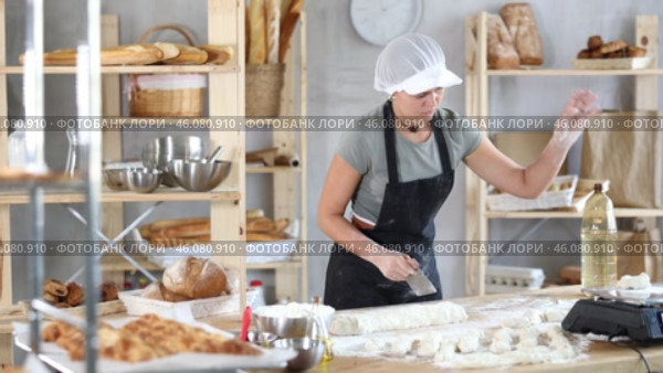 Woman baker cutting dough pieces with scraper and weighing in scales. Стоковое видео, видеограф Яков Филимонов / Фотобанк Лори