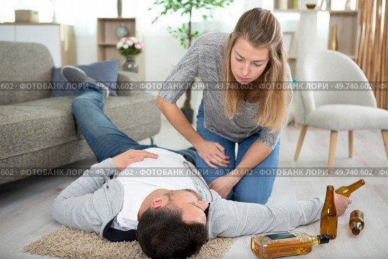 woman checking on drunk husband on the floor. Стоковое фото, агентство Ingram Publishing / Фотобанк Лори