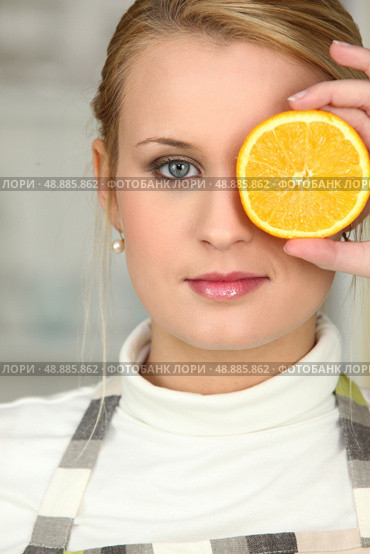 Woman covering her eye with orange slice. Стоковое фото, агентство Ingram Publishing / Фотобанк Лори