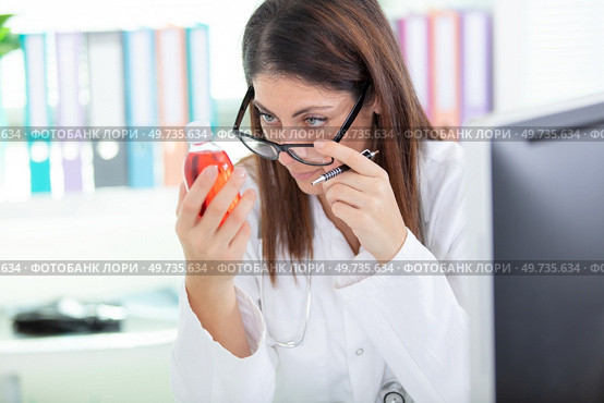 woman doctor checks cough remedy. Стоковое фото, агентство Ingram Publishing / Фотобанк Лори
