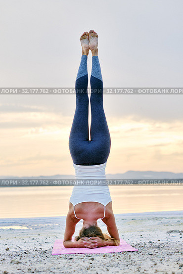 Woman doing Hatha yoga headstand or Sirsasana on nature rear view. Стоковое фото, фотограф Alexander Tihonovs / Фотобанк Лори