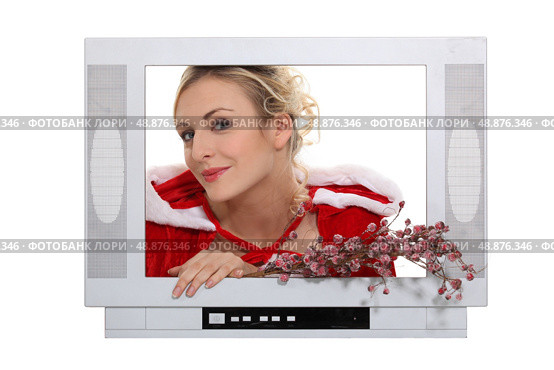 Woman dressed in festive outfit coming out of television. Стоковое фото, агентство Ingram Publishing / Фотобанк Лори