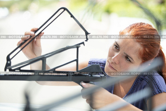 woman fastening roof bar fixation for bicycle. Стоковое фото, агентство Ingram Publishing / Фотобанк Лори