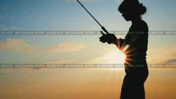 Woman fishing on Fishing rod spinning at sunset. A woman caught a fish, but she fell off the hook. Стоковое видео, видеограф Андрей Армягов / Фотобанк Лори