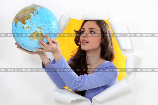 Woman getting out of hole with globe. Стоковое фото, агентство Ingram Publishing / Фотобанк Лори