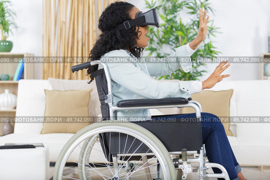 woman in wheelchair wearing virtual reality goggles. Стоковое фото, агентство Ingram Publishing / Фотобанк Лори