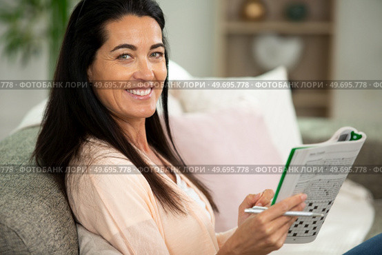 woman is solving crossword puzzles. Стоковое фото, агентство Ingram Publishing / Фотобанк Лори