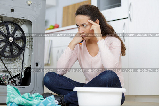 woman looking at leaking sink pipe. Стоковое фото, агентство Ingram Publishing / Фотобанк Лори