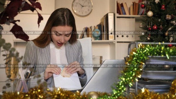 Woman office worker with wage packet in Christmas decorated office. Стоковое видео, видеограф Яков Филимонов / Фотобанк Лори