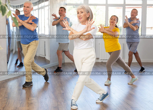 Woman participating in Zumba class for seniors in fitness studio. Стоковое фото, фотограф Яков Филимонов / Фотобанк Лори