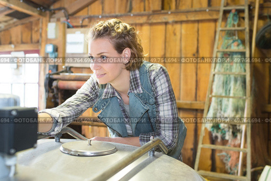 Woman pressing controls of metal container. Стоковое фото, агентство Ingram Publishing / Фотобанк Лори