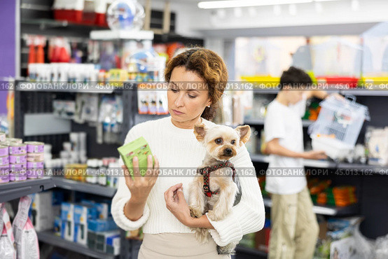 Woman selecting dry dog food for Yorkie in pet store. Стоковое фото, фотограф Яков Филимонов / Фотобанк Лори